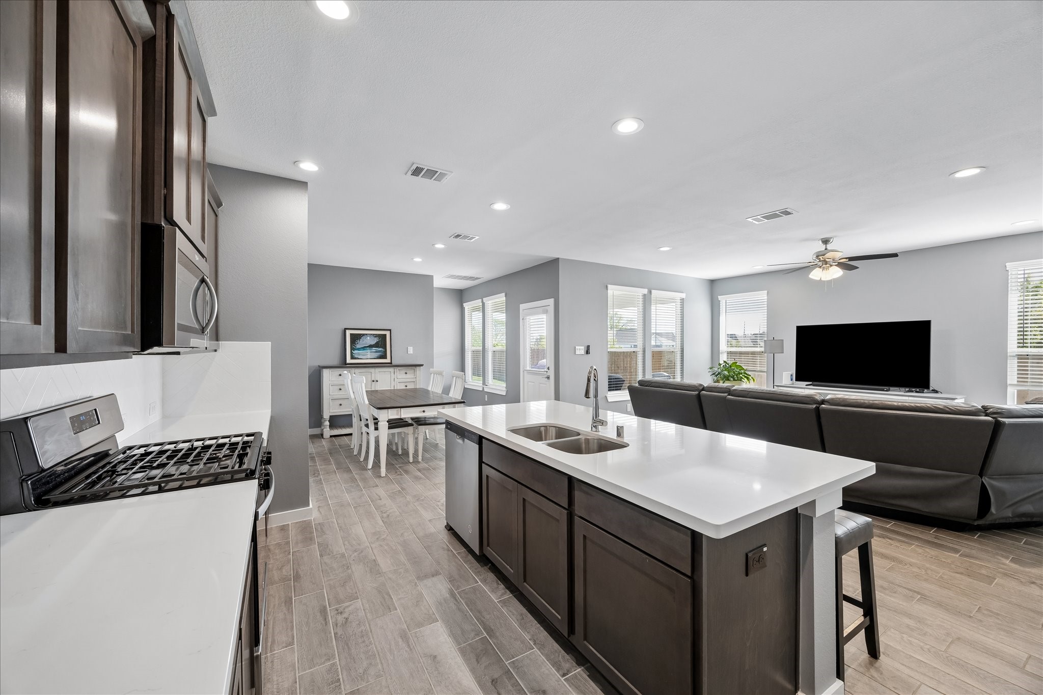 33002 Carolyns Perfection Loop Fulshear, TX 77441 - Photo 8 of 29 a kitchen with a sink stainless steel appliances and wooden floor
