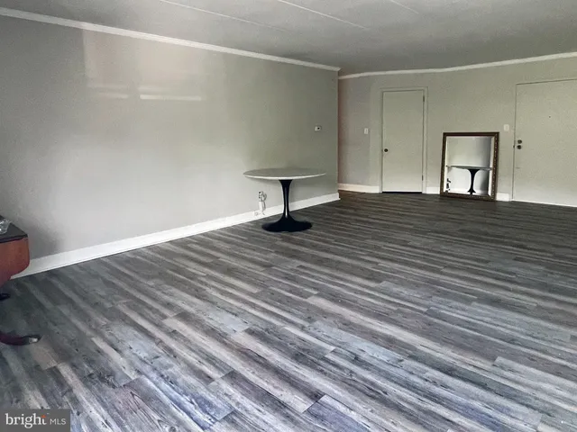 a view of a room with wooden floor and bench