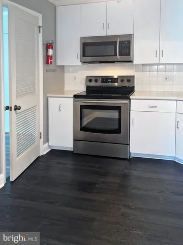 a kitchen with stainless steel appliances a stove a microwave and cabinets