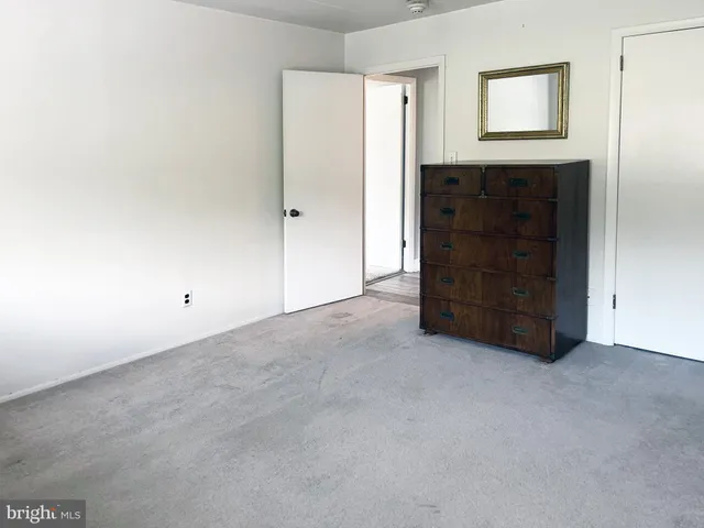 a view of an empty room with closet and cabinet