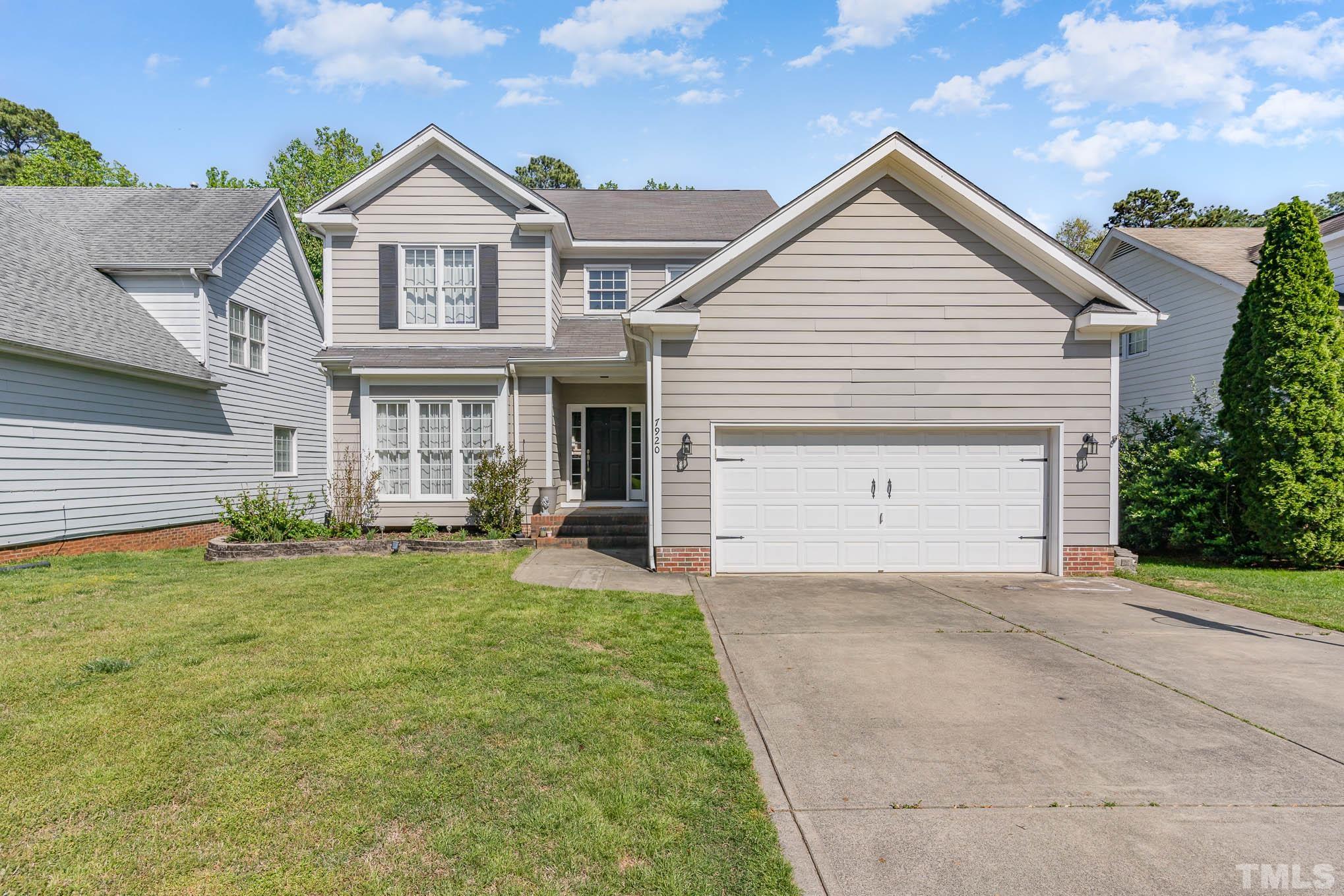 7920 Milltrace Run Raleigh, NC 27615 - Photo 4 of 9 a front view of a house with a yard and garage
