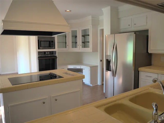 a view of kitchen with stainless steel appliances granite countertop a refrigerator and a stove