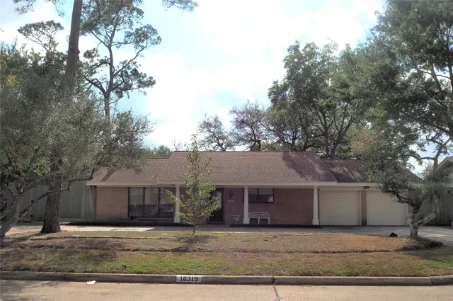 a white house that has a tree in front of it