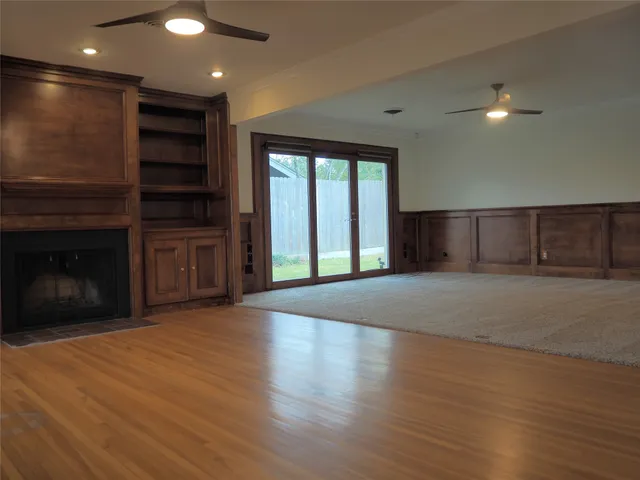a view of empty room with wooden floor and fireplace