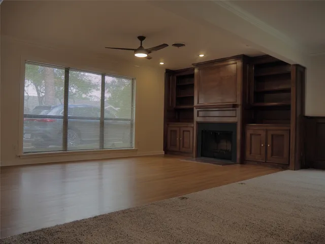 a view of an empty room with a fireplace and a window