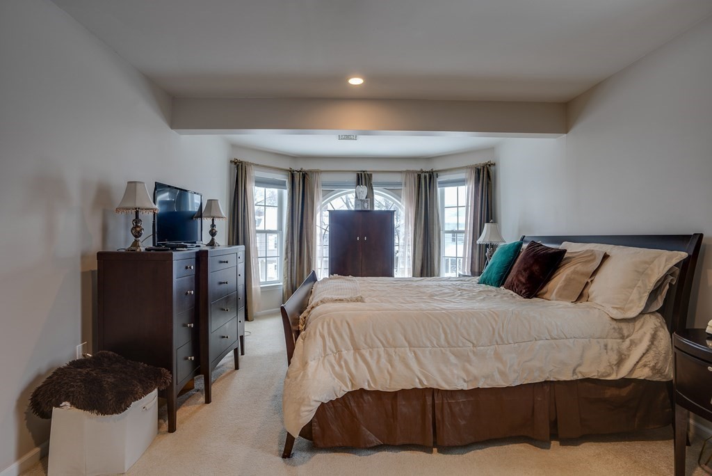 265 Renfrew Street Arlington, MA 02476 - Photo 20 of 39 a bedroom with a bed flat screen tv and windows