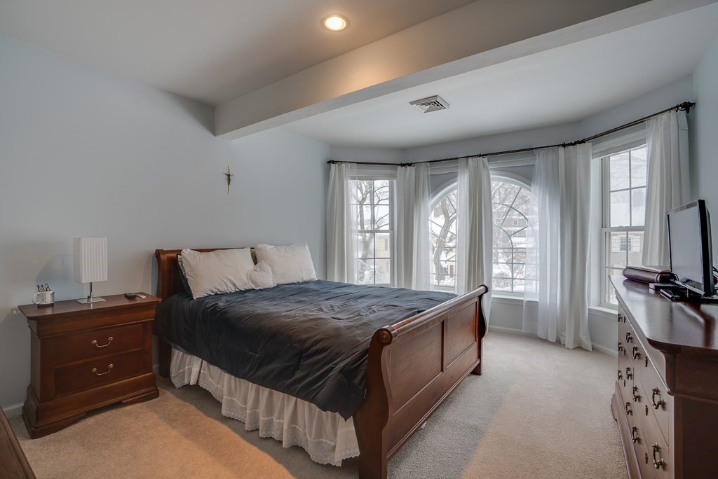 265 Renfrew Street Arlington, MA 02476 - Photo 28 of 39 a bedroom with a bed and a large window