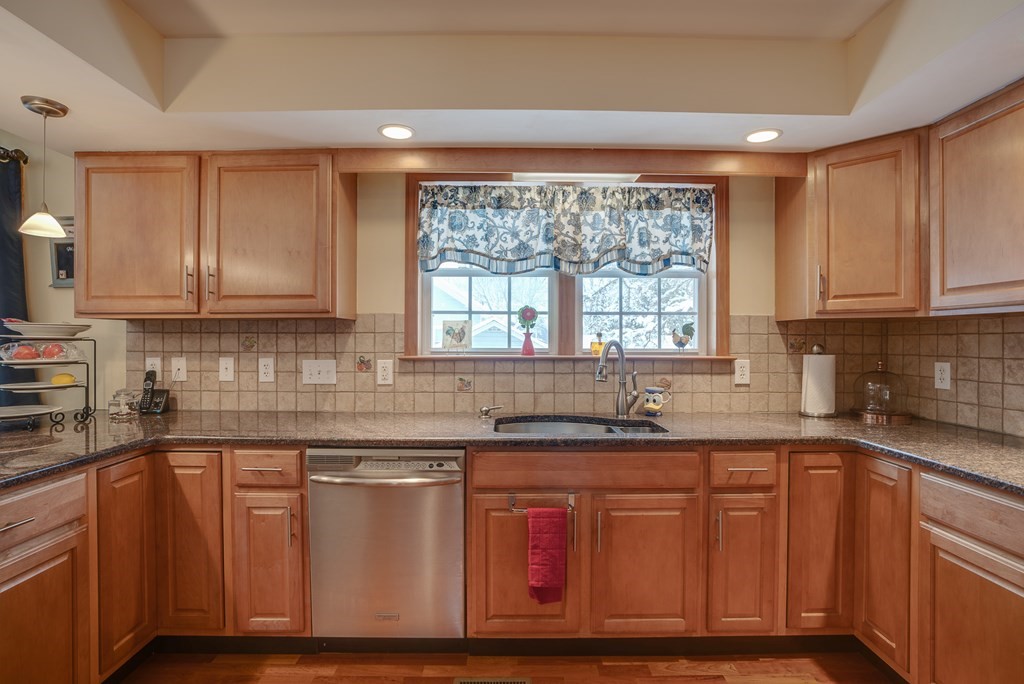 265 Renfrew Street Arlington, MA 02476 - Photo 7 of 39 a kitchen with granite countertop wooden cabinets stainless steel appliances a sink and a window