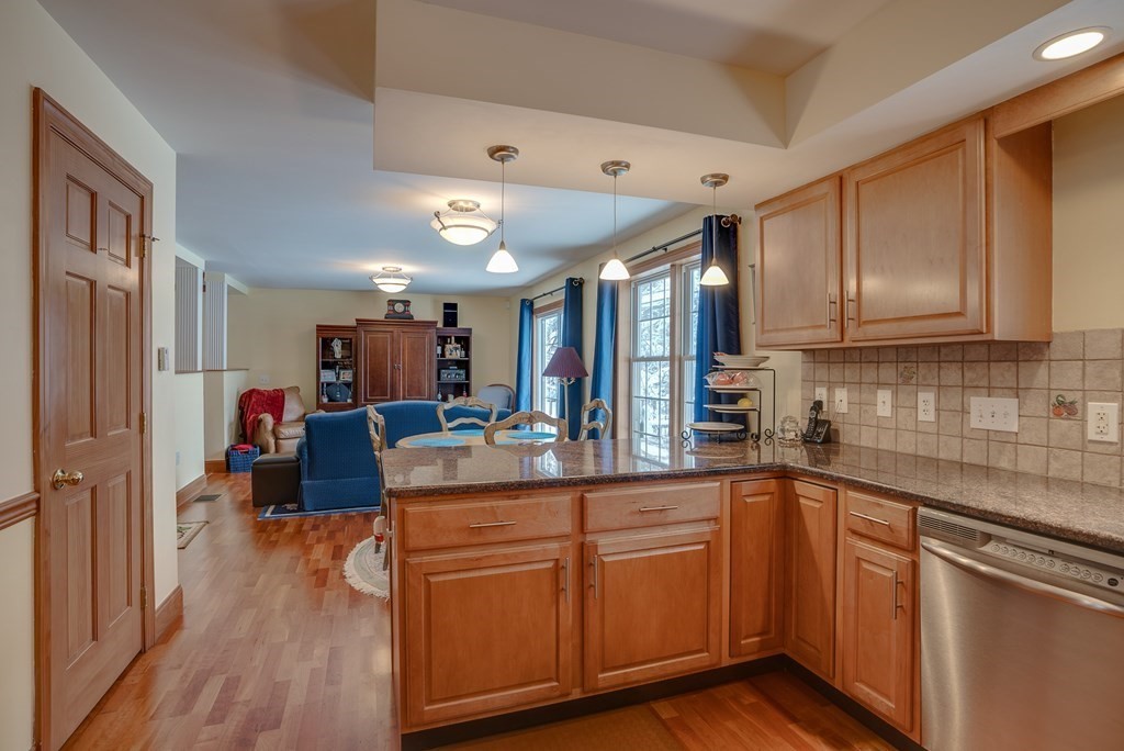 265 Renfrew Street Arlington, MA 02476 - Photo 9 of 39 a kitchen with kitchen island granite countertop a sink cabinets and wooden floor