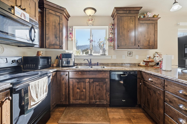 1084 South 740 East Logan, UT 84321 - Photo 5 of 23 Kitchen with black appliances, dark wood finish cabinetry, and dark wood-style floors