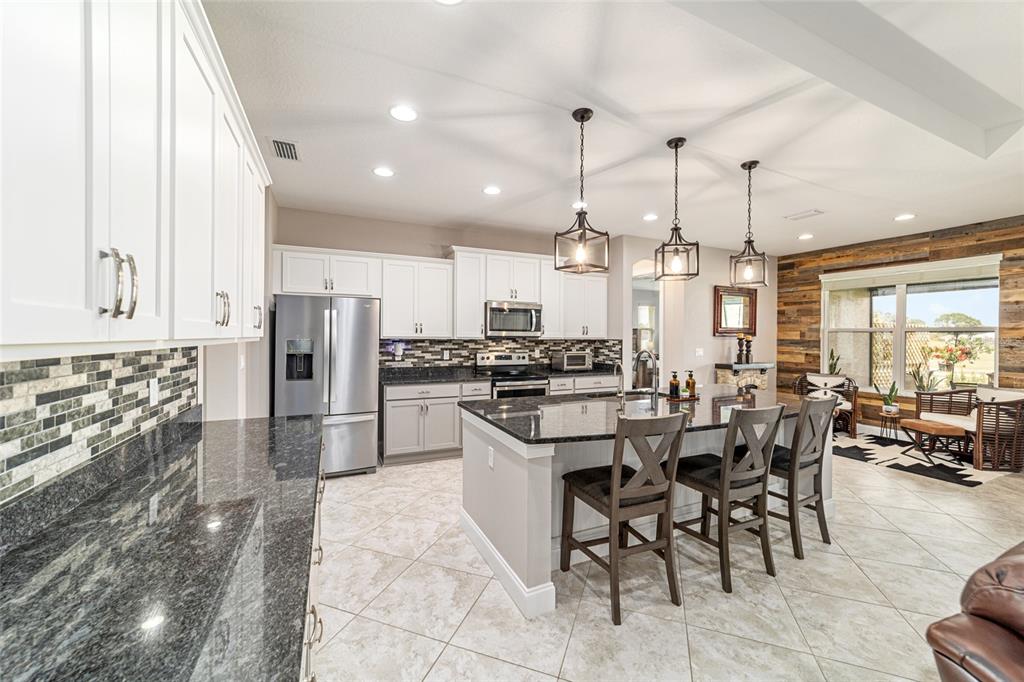 1983 Northwest 79th Loop Ocala, FL 34475 - Photo 20 of 97 a kitchen with stainless steel appliances kitchen island granite countertop a table and chairs in it