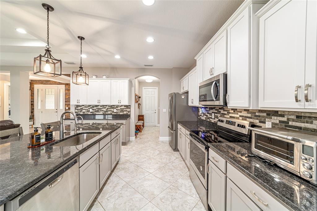 1983 Northwest 79th Loop Ocala, FL 34475 - Photo 24 of 97 a kitchen with stainless steel appliances granite countertop a sink a stove and a refrigerator