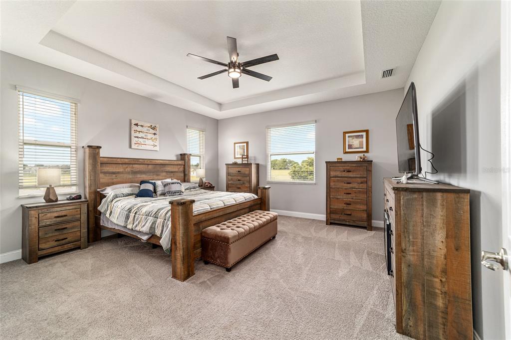 1983 Northwest 79th Loop Ocala, FL 34475 - Photo 33 of 97 a spacious bedroom with a bed and a chandelier