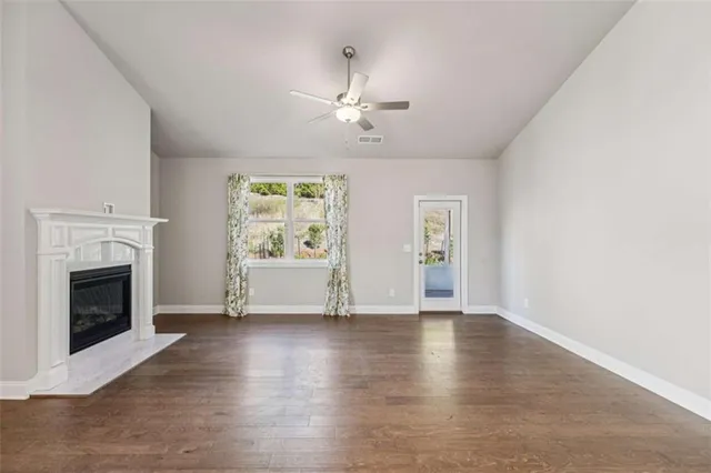 a kitchen with stainless steel appliances granite countertop a stove top oven a sink dishwasher a dining table and chairs with wooden floor