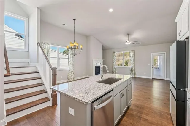 a kitchen with refrigerator and wooden floor