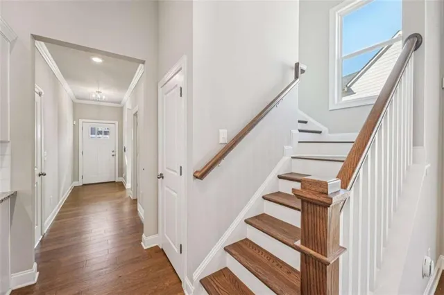 an empty room with wooden floor fireplace and windows