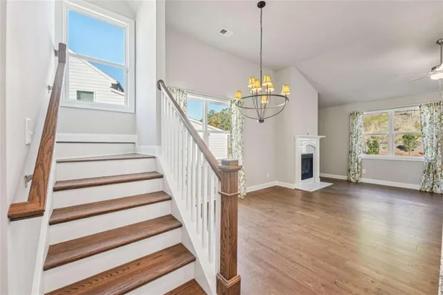 an empty room with windows fireplace and wooden floor