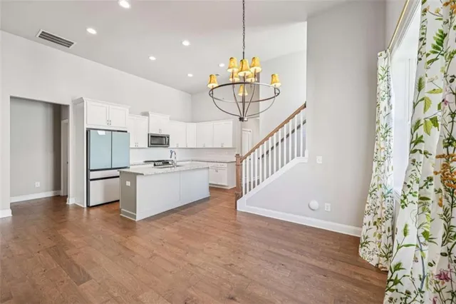 a view of an empty room with wooden floor a fireplace and a window