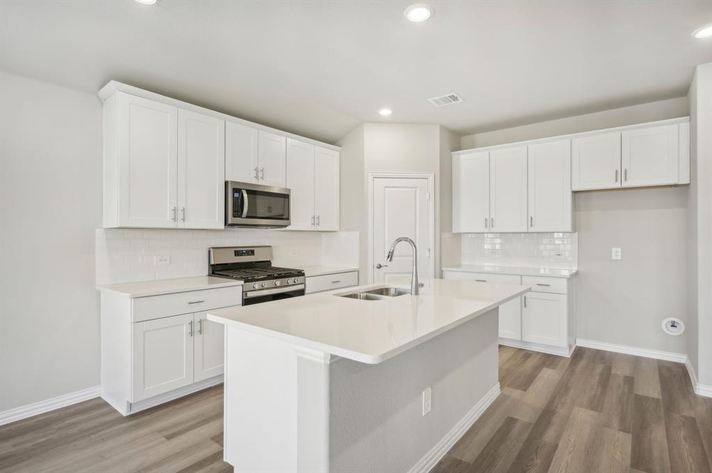 443 Sierra Ridge Lavon, TX 75166 - Photo 1 of 1 a kitchen with a sink stove and white cabinets