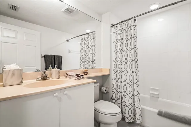 a bathroom with a sink a toilet and shower curtain