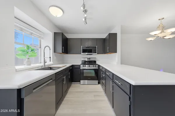 a modern kitchen with stainless steel appliances granite countertop a sink and a stove