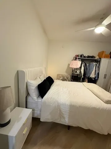 a bedroom with a bed and wooden floor