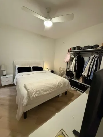 a bedroom with a bed and a refrigerator