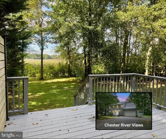 a view of a wooden deck and a yard with wooden fence
