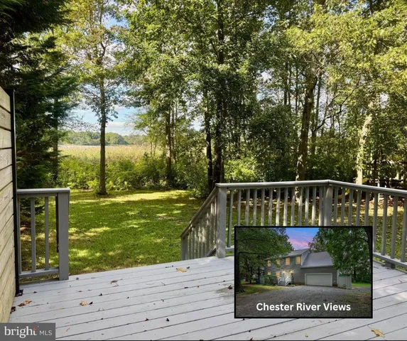 a view of a wooden deck and a yard with wooden fence