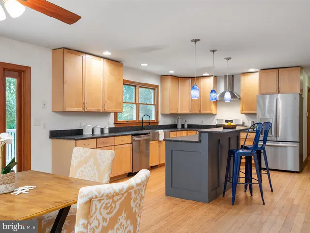 a kitchen with stainless steel appliances granite countertop a sink a stove and a refrigerator