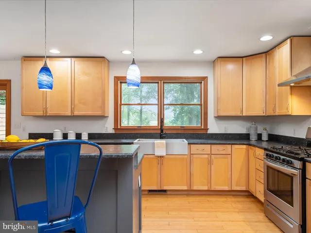 a kitchen with stainless steel appliances granite countertop a stove a sink and a refrigerator