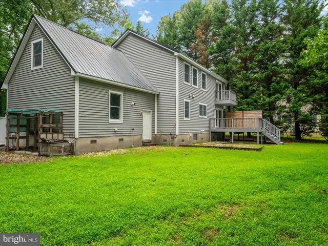 a view of a field with an ocean and trees in the background