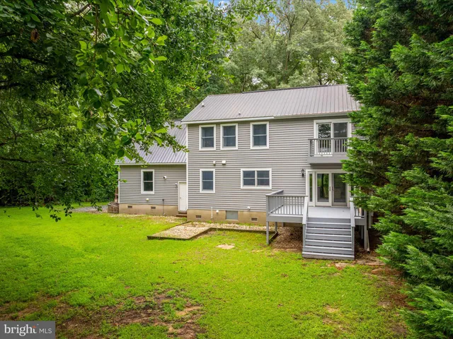 an aerial view of a houses with lake view and a yard