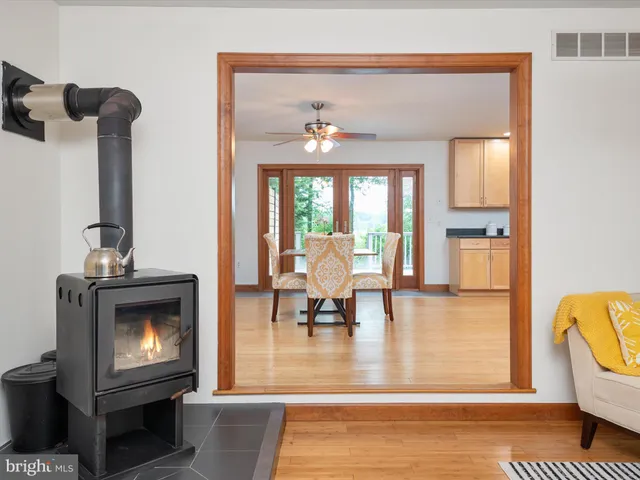 a kitchen with stainless steel appliances granite countertop a refrigerator a sink dishwasher a stove and a dining table with wooden floor