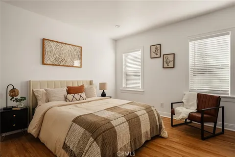 a bedroom with a bed and wooden floor