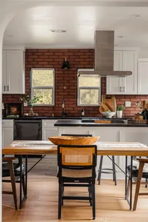 a kitchen with stainless steel appliances granite countertop table chairs sink and cabinets