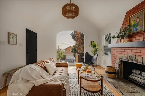 a living room with furniture a fireplace and a wall painting