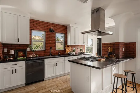 a kitchen with stainless steel appliances a sink dishwasher a stove a refrigerator and cabinets