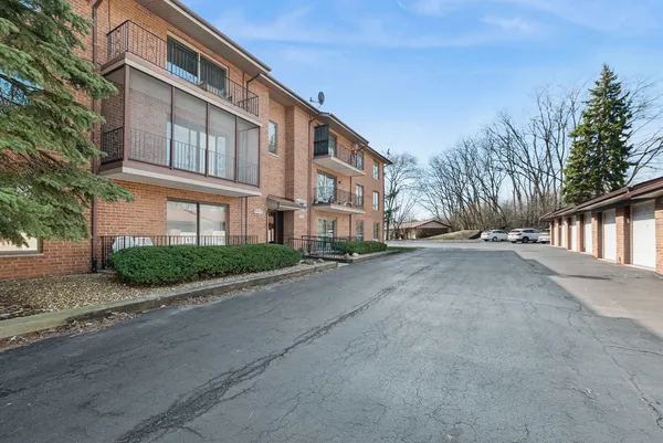 a front view of a house with a garden and trees