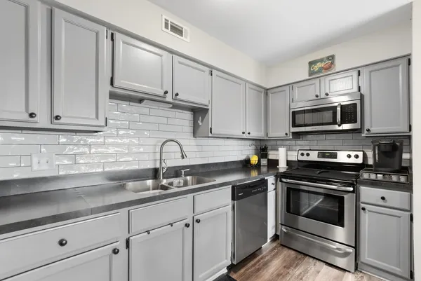 a kitchen with white cabinets stainless steel appliances and sink