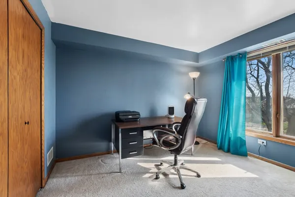 a view of a workspace with furniture and a window