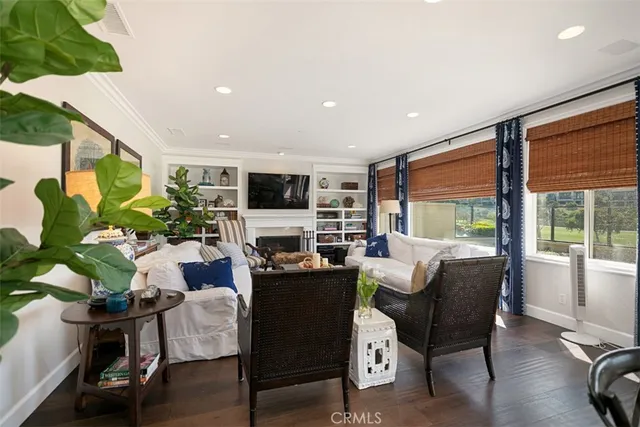 a living room with furniture kitchen view and a large window