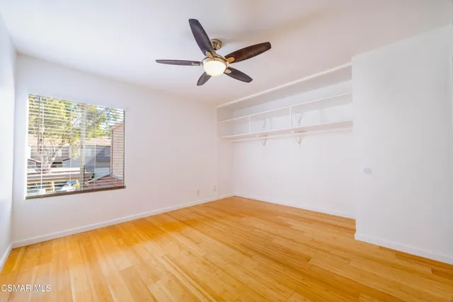 a view of a big room with wooden floor and windows