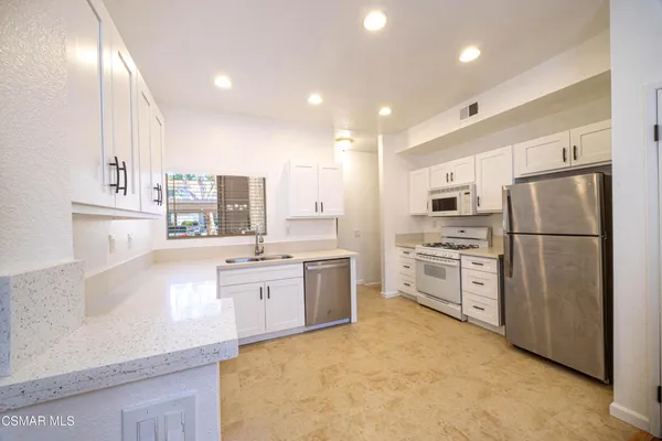 a kitchen with refrigerator cabinets and a sink