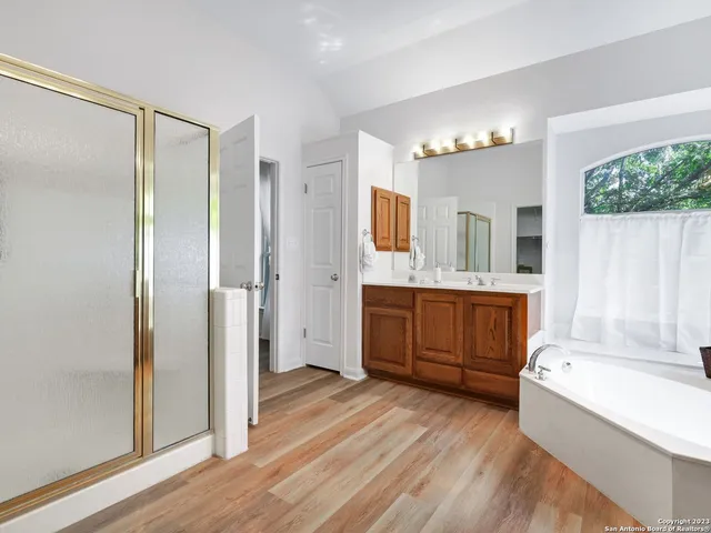 a bathroom with a tub shower vanity and a sink