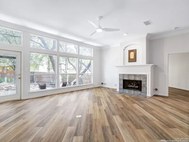 a view of empty room with wooden floor and fireplace