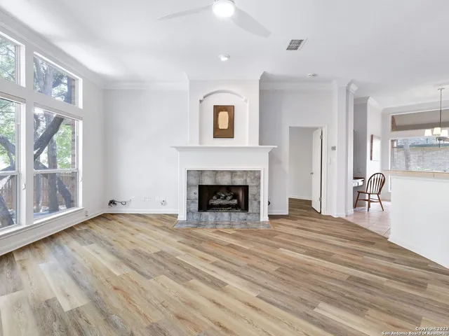 a view of a livingroom with a fireplace wooden floor and windows