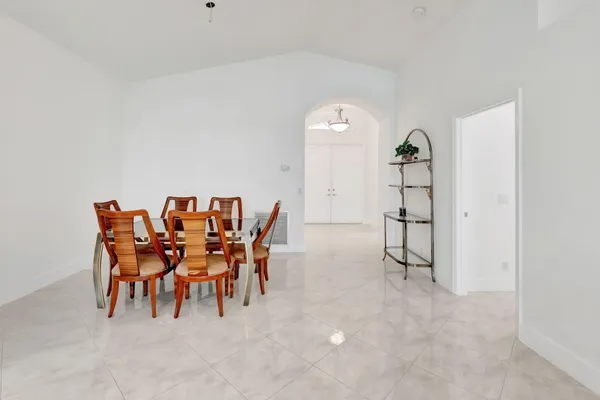 a dining room with furniture and a floor to ceiling window