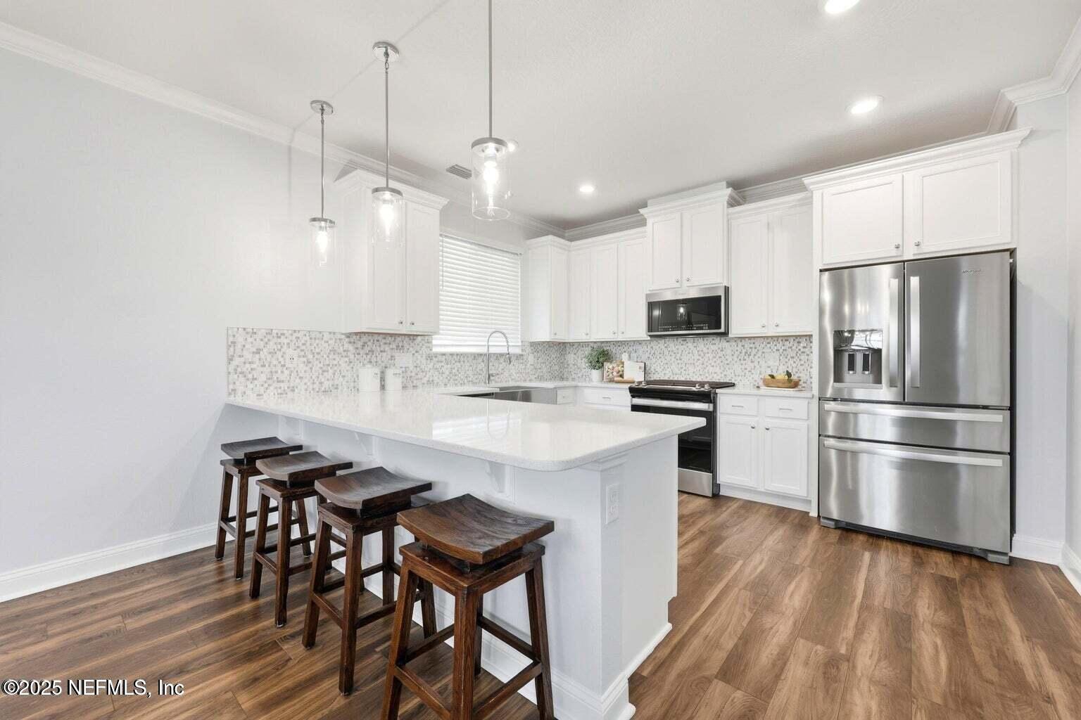 251 Rambling Brk Trail St. Johns, FL 32259 - Photo 12 of 40 a kitchen with kitchen island a refrigerator a stove a sink and a chairs