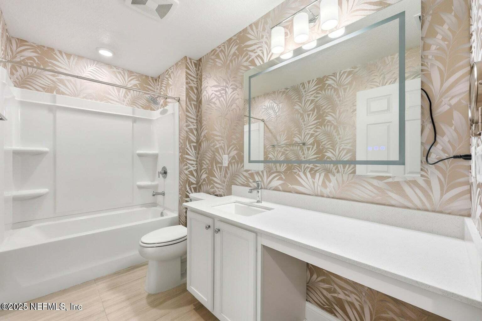 251 Rambling Brk Trail St. Johns, FL 32259 - Photo 32 of 40 a bathroom with a granite countertop sink a toilet a mirror a bathtub and shower